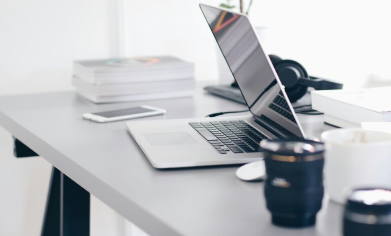 Computer, books, and cellphone on a desk